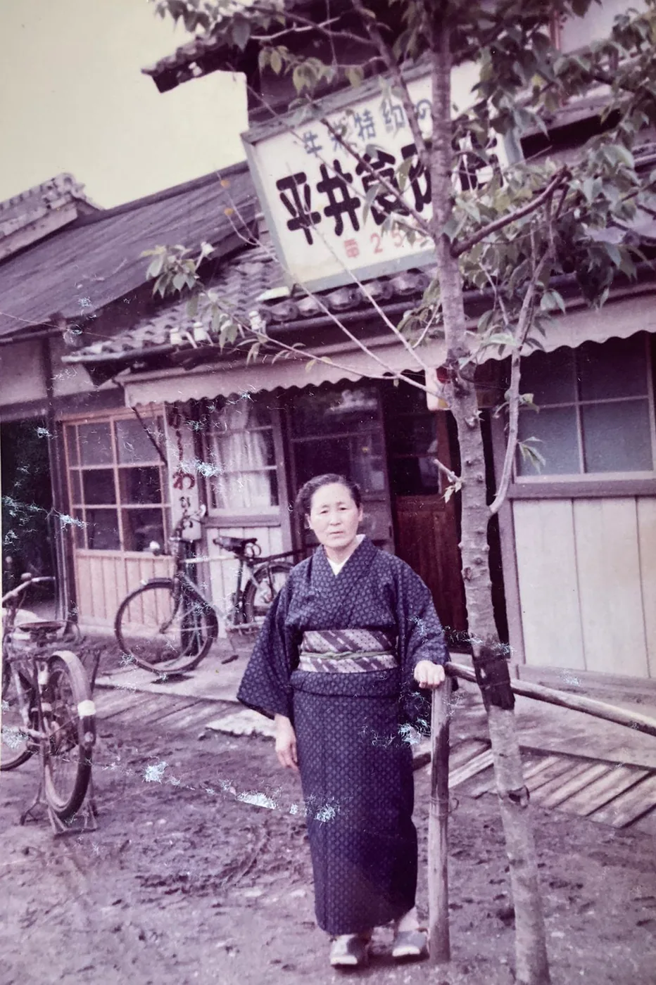 平井食肉店の店前に立つひいばあちゃん、平井スズエ