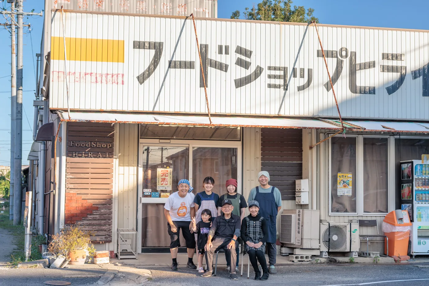 現在のフードショップヒライの外観と2026年の店前集合写真